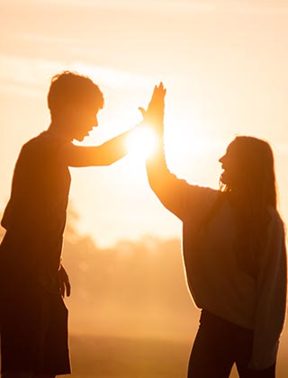 Mujer y hombre celebrando con el sol en la espalda